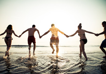 Friends running into ocean