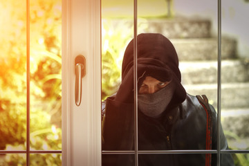 Burglar breaking in a house