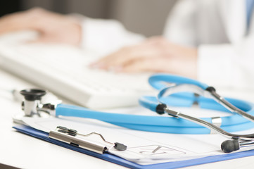 Female doctor taping on a computer keyboard 
