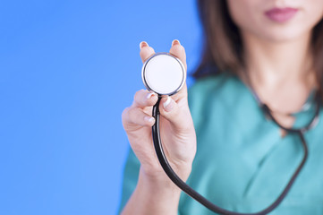 Female doctor holding up the disc of a stethoscope 