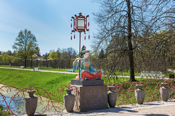 Fototapeta na wymiar vivid green summer view to Chinese sculptures in Pushkin, Russia.