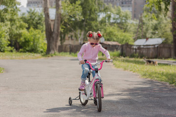 Fototapeta premium girl rides a bicycle on a warm summer track