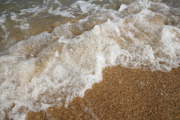 close up wave on a sand beach, sea foam, splash of the sea