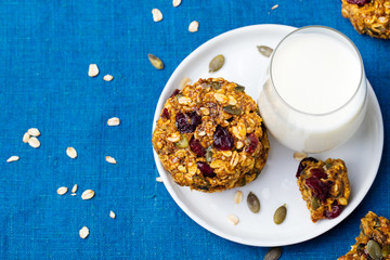 Pumpkin, oat cookies with cranberries, maple glaze and glass of milk Copy space. Top view