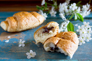 Mug of coffee and a croissant on the vintage wooden table, space