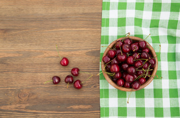 Sweet cherries with  on brown wooden background