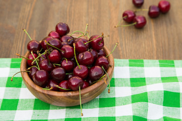 Sweet cherries with  on brown wooden background