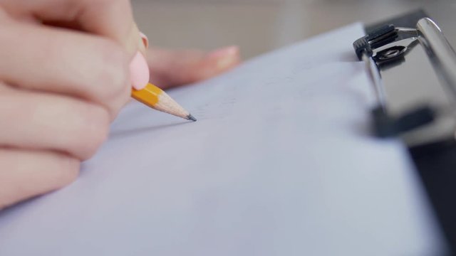 Close up of female hand making notes in the writing pad