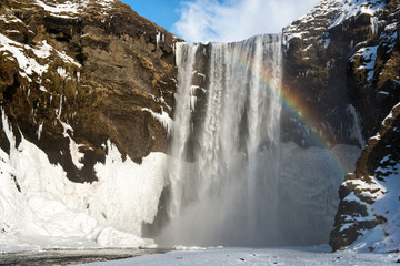 Beautiful winter landscape, Skogafoss waterfall with rainbow, Iceland