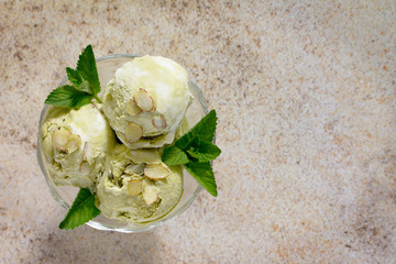 Delicious ice cream pistachio and almond petals on a brown stone