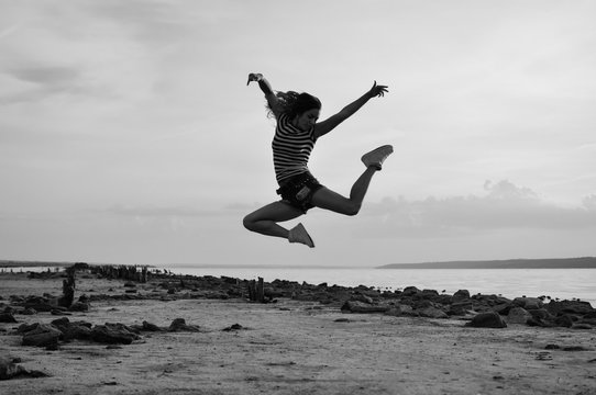 Black white photography of beautiful young lady jumping 