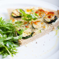 Whole Grain pizza with vegetables and fresh salad on a white plate Selective focus