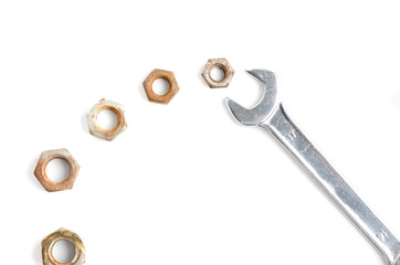 Metal Wrench and many rusted nuts isolated on white