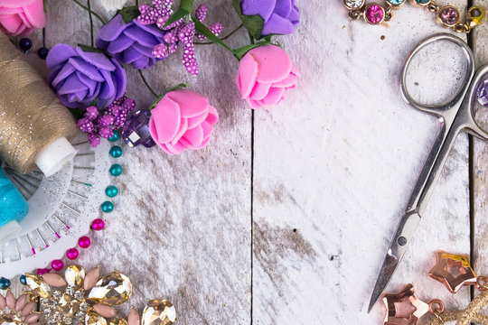 Plastic berries, flowers, beads and instruments on white wood background