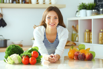 Young woman sitting near desk in the kitchen