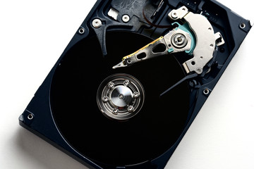 Hard disk drive internals inside close up with black disc surface and heads exposed