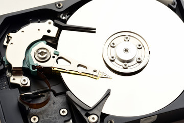 Computer hard disk drive internals with exposed disc surface and heads close up
