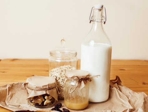 real comfort wooden kitchen with breakfast ingredients close up in glass, honey, oatmeal, milk, muesli