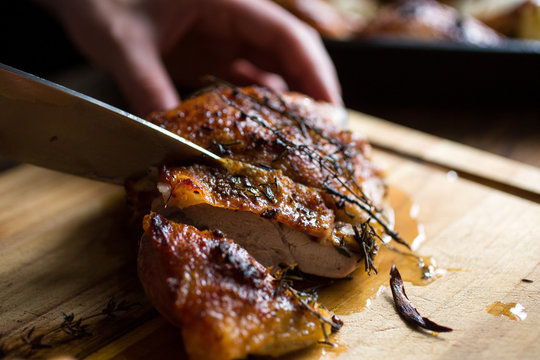 Person Slicing Roast Turkey With Knife