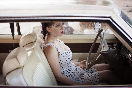 Side View Of A Wet Woman Sitting In A Car