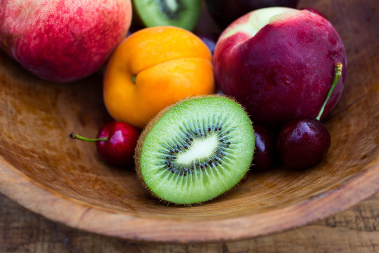 Fresh fruits in wooden bowl