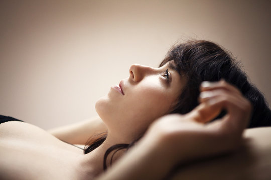 Woman lying on back in bed