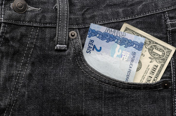 One dollar and two brazilian money inside jeans pocket