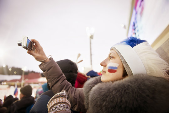 Young woman photographing during political gathering