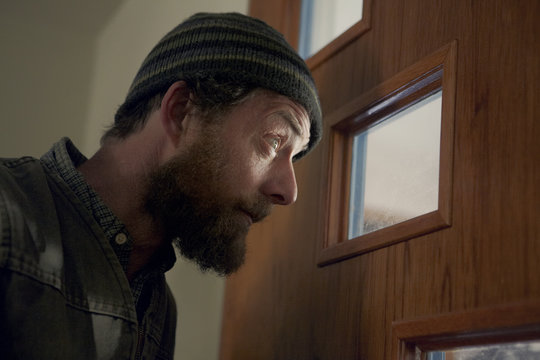 Suspicious man looking through window