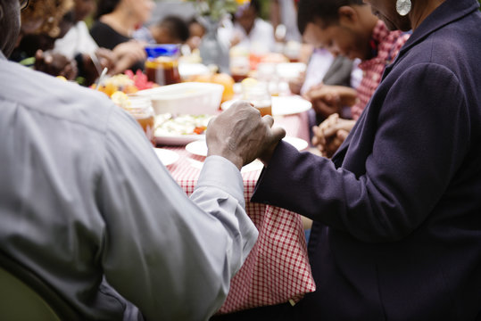 Family members holding hands while saying grace