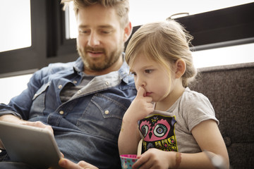 Father with daughter (4-5) using digital pc at home