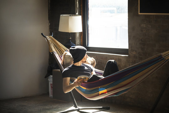 Young man reading book in hammock