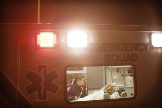 Paramedic taking care of patient in ambulance at night