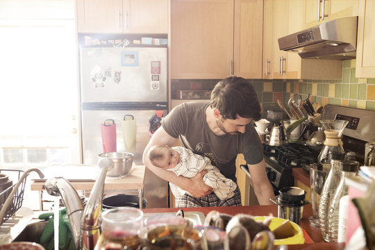 Man cooking with his baby son (0-1) months