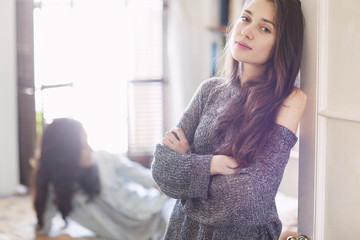 Backlit of young woman leaning in bedroom doorway
