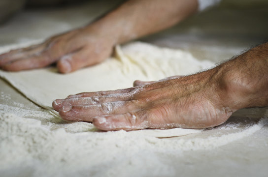 Close-up of a man preparing pizza dough