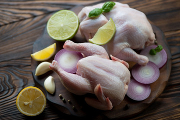 Close-up of two raw chickens with condiments, selective focus