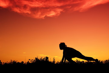 Naklejka premium Silhouette a girl start running at sunset