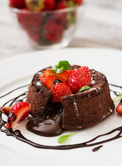 Chocolate fondant (cupcake) with strawberries and powdered sugar