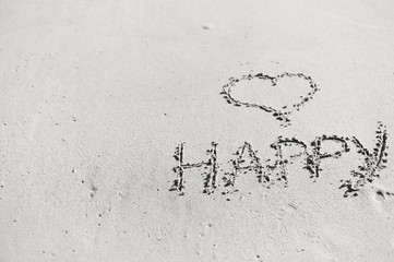 Love heart and happy word, honeymoon or valentine's day greetings on the sand