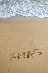 Xmas word sign on tropical beach background