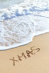 Xmas word sign on tropical beach background