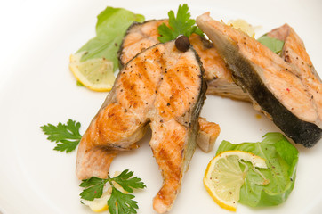 several salmon steaks round plate spices