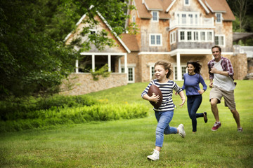 Happy family playing rugby at garden