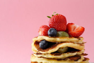 pancakes with berries against pink background