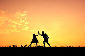Fototapeta na wymiar Silhouette children hands up in the sunset.Relax time