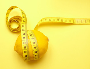 lemon with a measuring tape on a yellow background