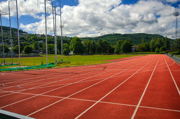 Running tracks in stadium among trees and mountains