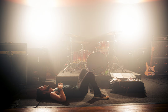 Side view of man lying on floor in rock music studio