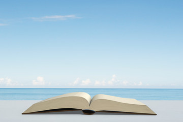 Opening book on desk outdoor with sea and blue sky,3D rendering